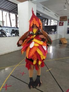 A student is imitating a bird in a fancy dress competition.