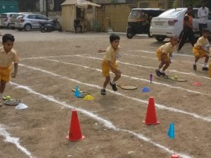 Preschool students enjoying playing on the ground during the sports activity.